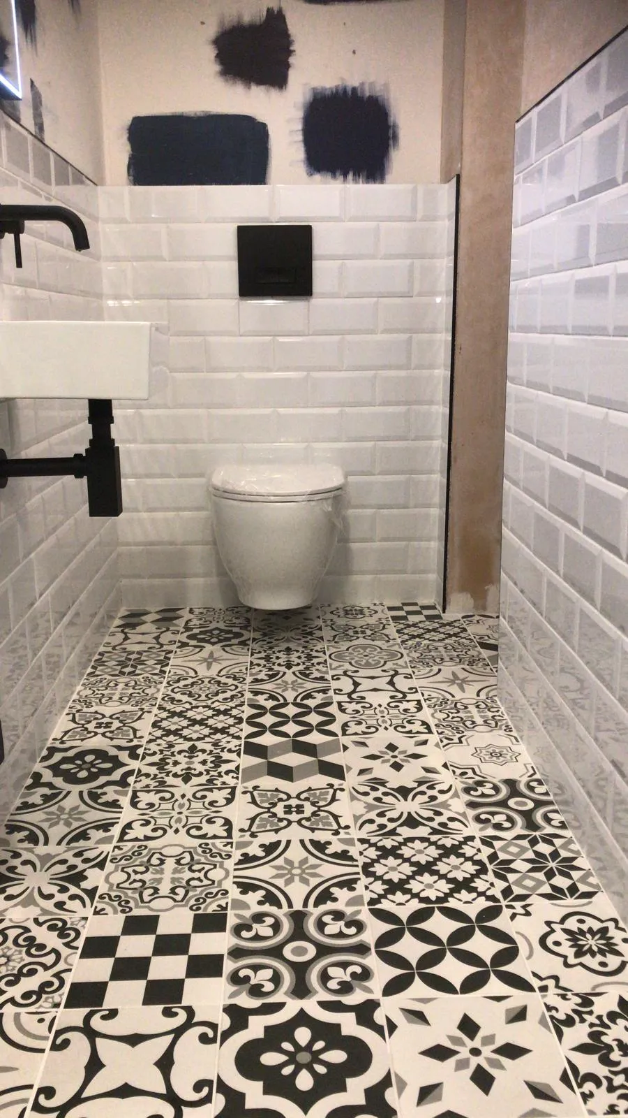 A white toilet sitting next to a white sink in a bathroom.
