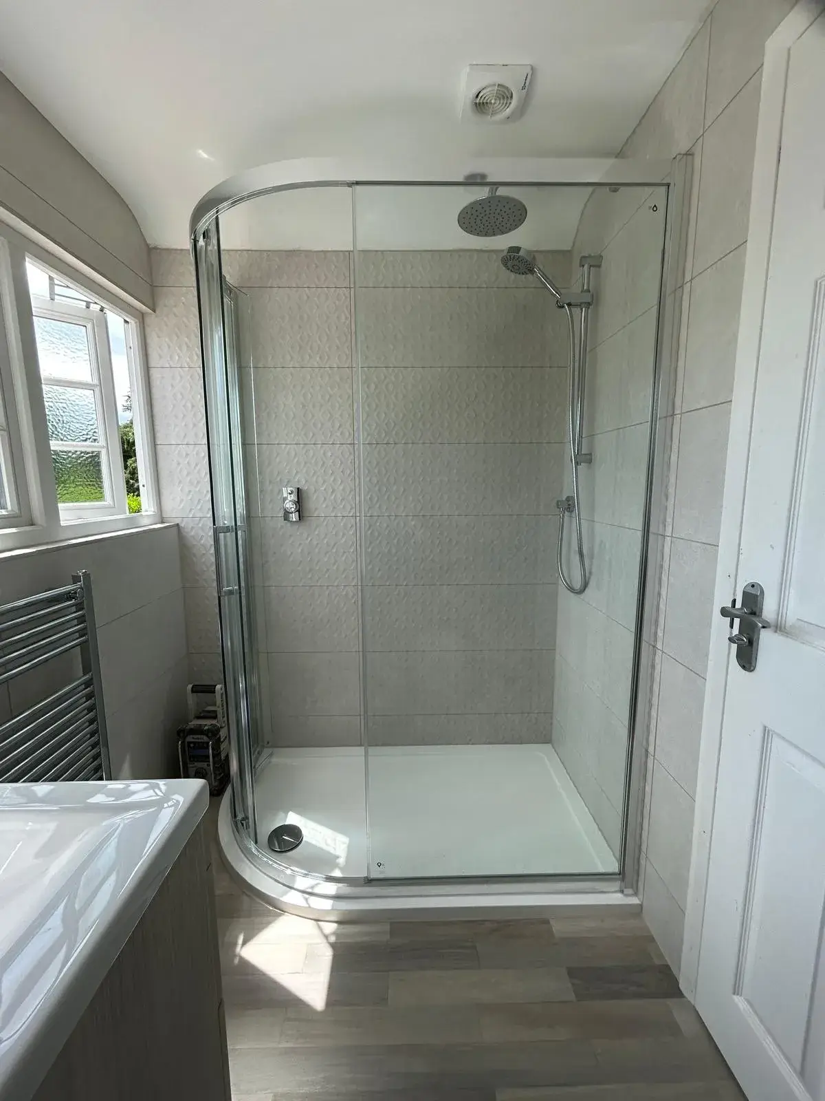 A bathroom with a walk in shower next to a sink.